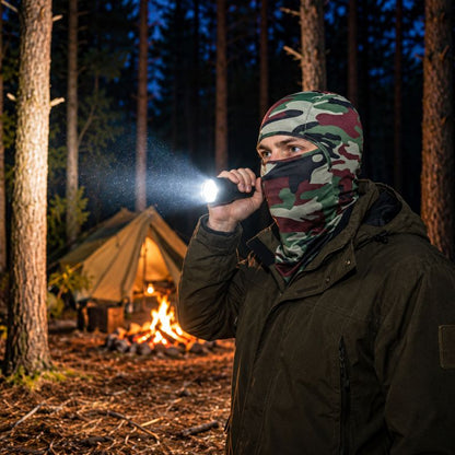 Cagoule TerraCamo portée avec lampe torche près campement forestier nocturne