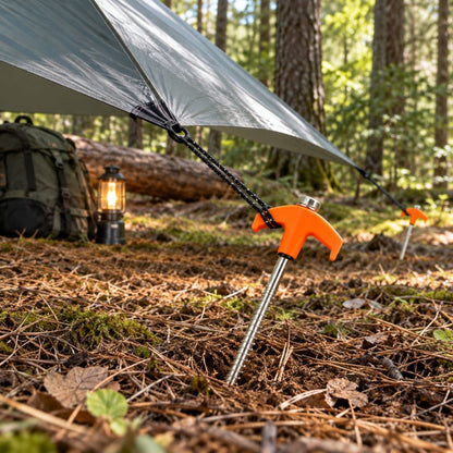 Piquet de tente TerraScrew orange fixant tarp au campement forestier