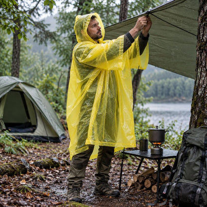 Poncho pluie RainFlex jaune homme installant campement sous pluie fine