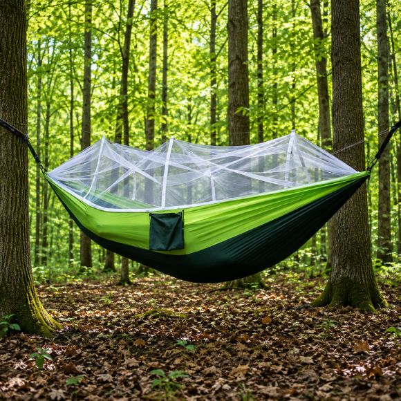 Hamac moustiquaire TrekShield suspendue vert et noir installé entre des arbres.