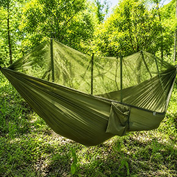 Hamac moustiquaire suspendue vert kaki installé en forêt, offrant une protection contre les insectes en camping.
