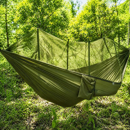 Hamac moustiquaire suspendue vert kaki installé en forêt, offrant une protection contre les insectes en camping.