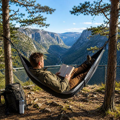 Hamac suspendue de camping Évasion Totale avec un randonneur lisant un livre.