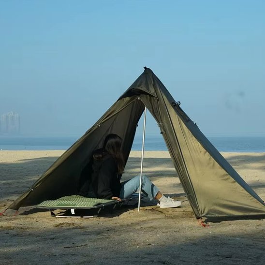 Tente camping Tente de camping tipi imperméable avec sortie de cheminée installée sur un terrain herbeux en forêt